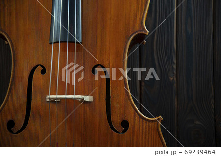 Fragment of a beautiful cello or violin on a wooden background with place for text 69239464