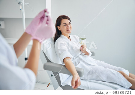 Smiling woman with a catheter in her vein looking away 69239721