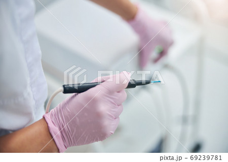 Qualified cosmetologist preparing for an electrosurgical procedure Qualified cosmetologist preparing for an electrosurgical procedure 69239781