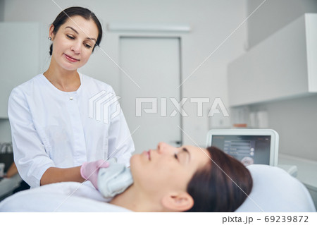 Doctor looking at her patient during a cosmetic procedure Doctor looking at her patient during a cosmetic procedure 69239872