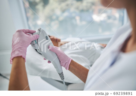 Dermatologist preparing for a cosmetic procedure on a patient face 69239891