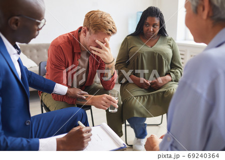 Young Man Crying in Support Group 69240364