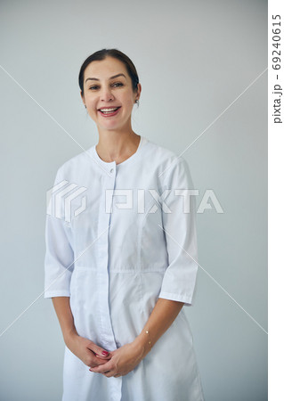 Attractive merry dark-haired female doctor looking ahead 69240615