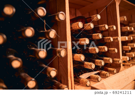 Bottles of wine stored in wooden racks Bottles of wine stored in wooden racks 69241211