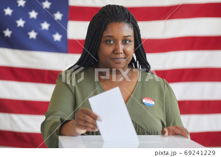 African-American Woman Putting Vote in Ballot Box African-American Woman Putting Vote in Ballot Box 69241229