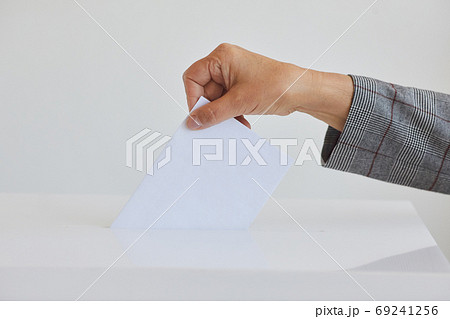 Hand Putting Envelope in Ballot Box Close Up 69241256
