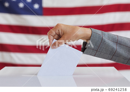 Female Hand Putting Vote in Ballot Box 69241258