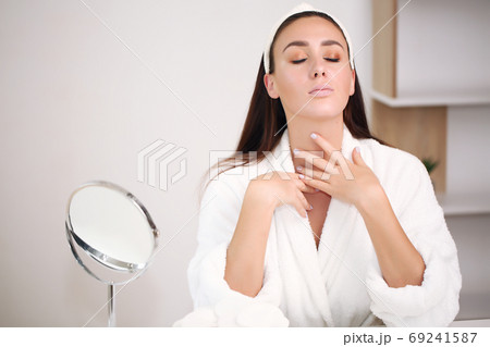beautiful brunette in a bathrobe at home, brings beauty, a hoop on his head beautiful brunette in a bathrobe at home, brings beauty, a hoop on his head 69241587