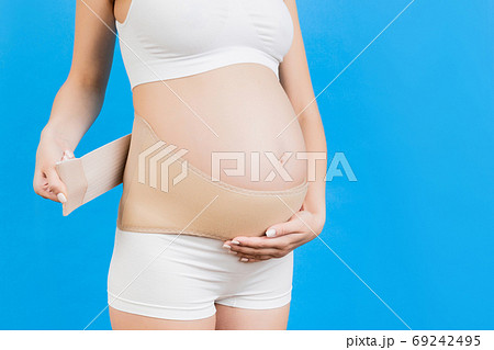 Back View Of Pregnant Woman In Underwear Wearing Elastic Maternity