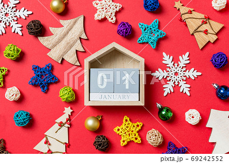 Top view of calendar on red background made of holiday decorations and toys. Christmas ornament concept Top view of calendar on red background made of holiday decorations and toys. Christmas ornament concept 69242552
