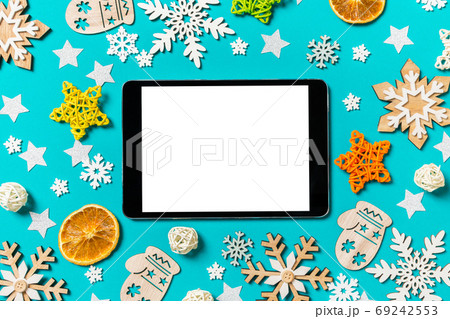 Top view of digital tablet on blue background with New Year toys and decorations. Christmas time concept 69242553