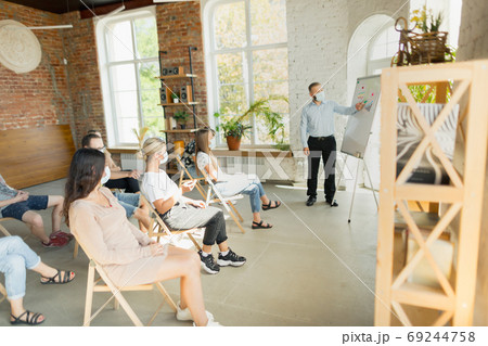 Male speaker giving presentation in hall at university workshop. Audience or conference hall Male speaker giving presentation in hall at university workshop. Audience or conference hall 69244758