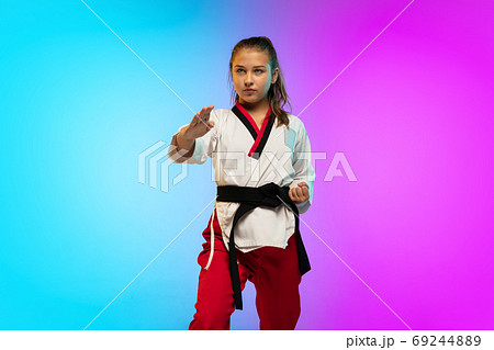 Karate, taekwondo girl with black belt isolated on gradient background in neon light 69244889