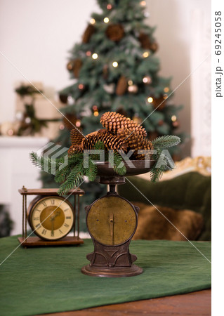 Stylish antique decor with pine cones. A handful of pine cones on an antique bronze scale Stylish antique decor with pine cones. A handful of pine cones on an antique bronze scale 69245058