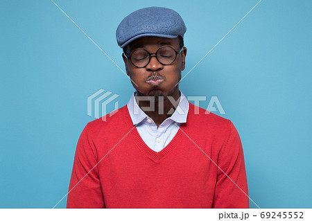 Young handsome african man puffing cheeks with funny face holding breath. 69245552