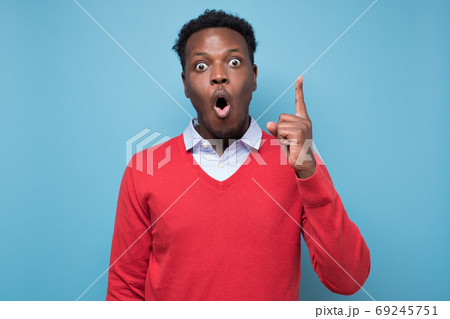 Surprised african man pointing up finger giving advice 69245751