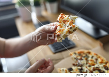 Man eating pizza at workplace close up 69245827