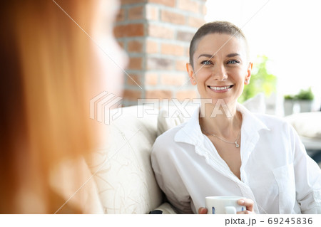 Smiling cute young woman on couch 69245836