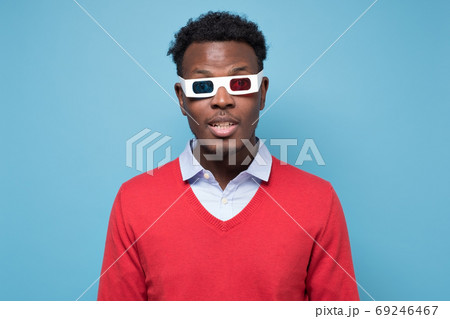 African american man in 3D glasses watching interesting movie on screen. African american man in 3D glasses watching interesting movie on screen. 69246467