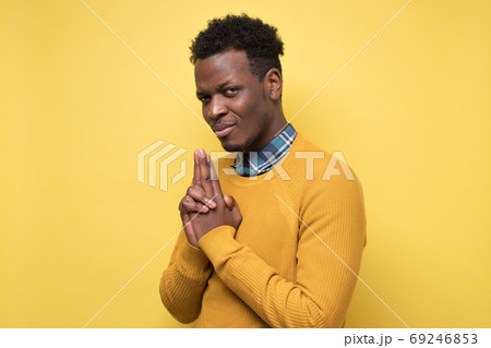 African man holding hand on chin and looking at camera generating idea. African man holding hand on chin and looking at camera generating idea. 69246853