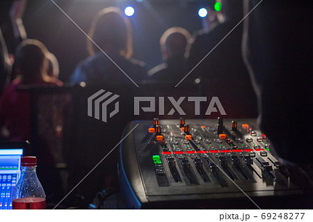 Soundman working on the mixing console. Soundman working on the mixing console. 69248277
