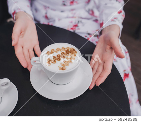 Female hands holding cup of coffee. 69248589