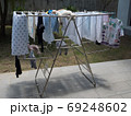 Baby clothes and diapers are exposed to the sun in the backyard. 69248602