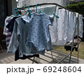 Baby clothes and diapers are exposed to the sun in the backyard. 69248604