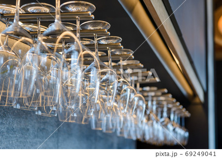 empty wine glasses hanging on rack in bar 69249041