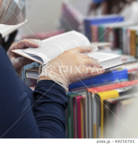 Closeup of women hands with a book in protective medical gloves, new reality. Healthcare concept, quarantine, personal protection 69250703