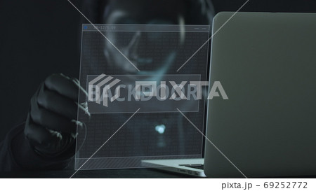 A hacker wearing black mask pulls BACKDOOR tab from a laptop. Hacking concept A hacker wearing black mask pulls BACKDOOR tab from a laptop. Hacking concept 69252772
