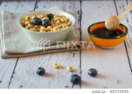 Honey rings with blueberries in a bowl on wooden background. Breakfast 69253940
