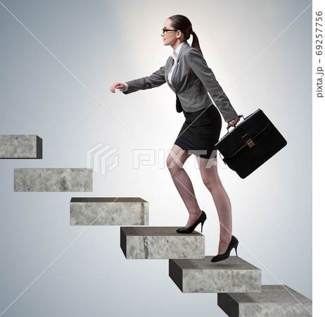 Businesswoman climbing career ladder in business concept 69257756
