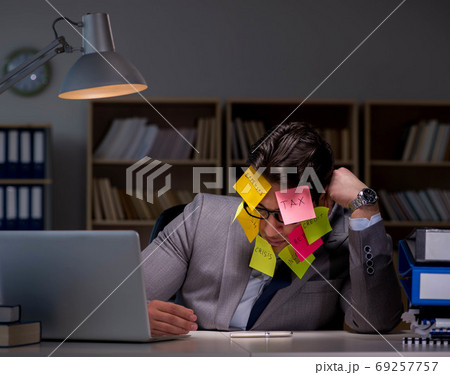 Businessman staying late to sort out priorities 69257757
