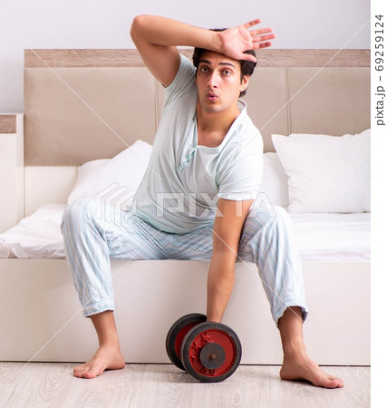 Young man doing morning routine in bedroom Young man doing morning routine in bedroom 69259124