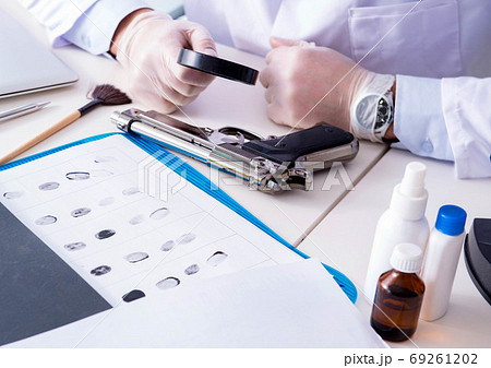 Criminologist police chemist looking at crime evidence Criminologist police chemist looking at crime evidence 69261202