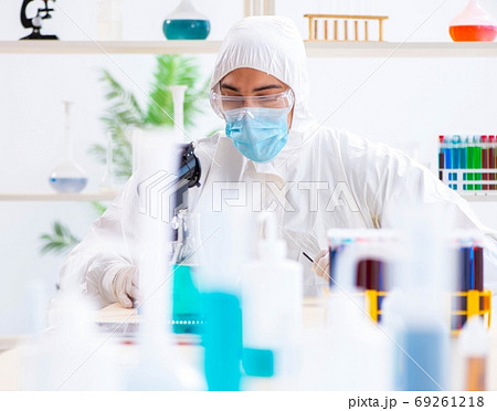 Young chemist student working in lab on chemicals 69261218