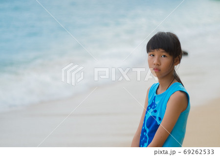 A lonely Asian girl with the sun and the beach by the sea on a clear day. A lonely Asian girl with the sun and the beach by the sea on a clear day. 69262533