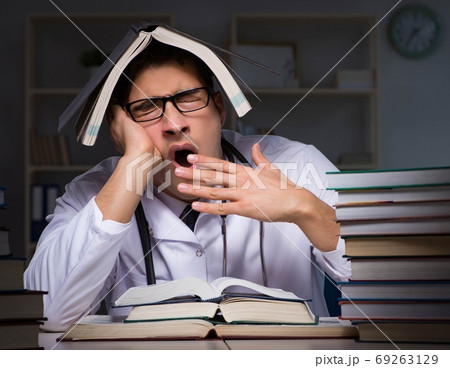 Medical student preparing for university exams at night 69263129