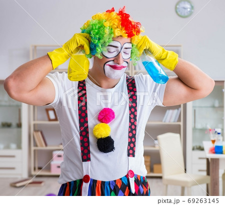 The funny clown doing cleaning at home 69263145