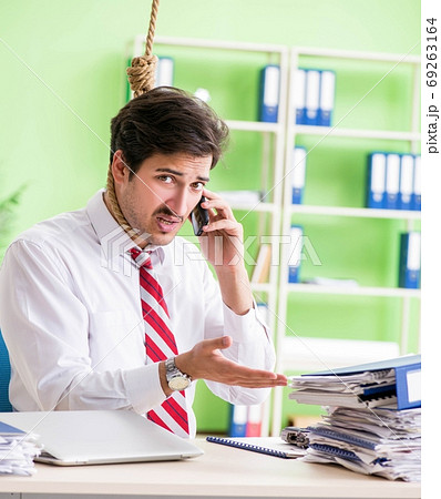 Despaired businessman thinking of suicide in the office 69263164