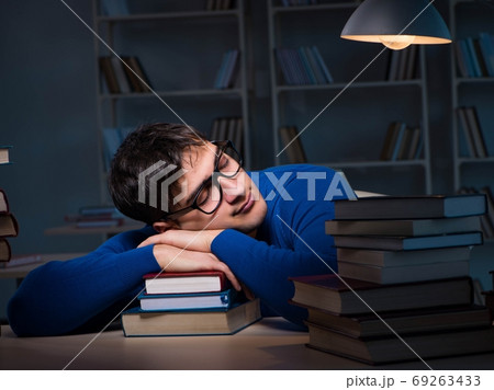 Student preparing for exams late at night in library 69263433