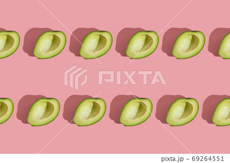 Trending style pattern of half seedless green avocado on pink background with hard light. Creative food texture. Trending style pattern of half seedless green avocado on pink background with hard light. Creative food texture. 69264551