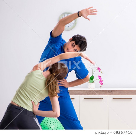 Fitness instructor helping sportsman during exercise Fitness instructor helping sportsman during exercise 69267416