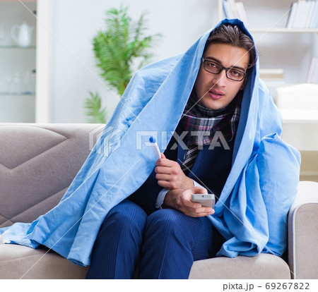 Employee businessman watching tv while being sick with flu Employee businessman watching tv while being sick with flu 69267822