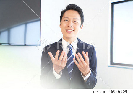 カメラに向かって笑顔で話しかけるビジネスマン 69269099