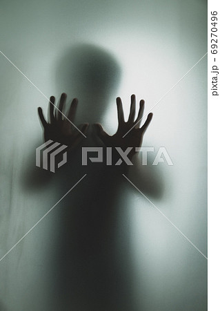 Ghost concept shadow of a men behind the matte glass blurry hand Ghost concept shadow of a men behind the matte glass blurry hand 69270496