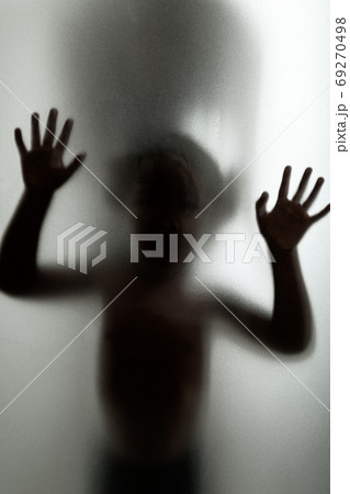 Ghost concept shadow of a child behind the matte glass blurry ha 69270498