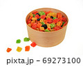 Assorted candied fruits in a wooden pot on a white background 69273100