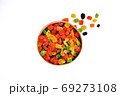 Assorted candied fruits in a wooden pot on a white background 69273108